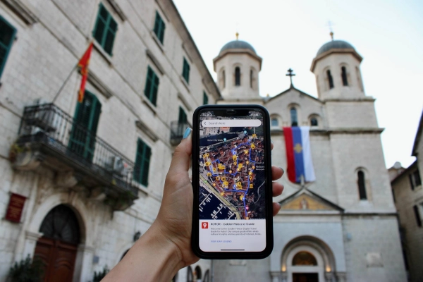 Smartphone with a map app open in front of St. Nicholas Church in Kotor