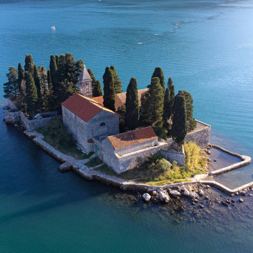 Mystical island near Perast in the Bay of Kotor, surrounded by pine trees and high stone walls
